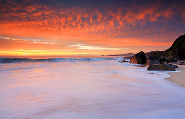 Image showing Dramatic red skies and frothy white waves beaches