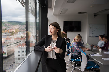 Image showing Business Girl Standing In A Modern Building Near The Window With