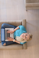 Image showing Young woman using laptop at home top view