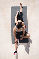 Image showing woman with personal trainer doing morning yoga exercises top vie