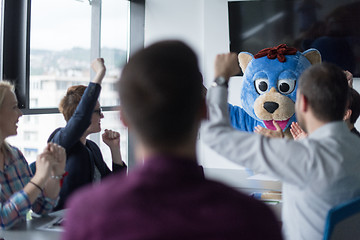 Image showing boss dresed as bear having fun with business people in trendy of