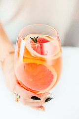 Image showing The rose exotic cocktails and fruits and female hand