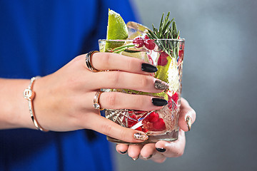 Image showing The exotic cocktail and female hands