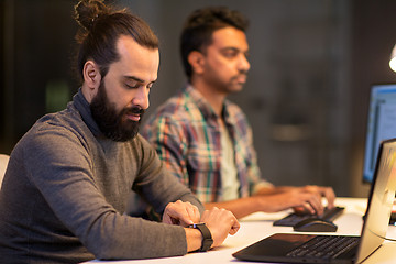 Image showing creative man with smartwatch working at office