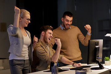 Image showing business team celebrating success at night office