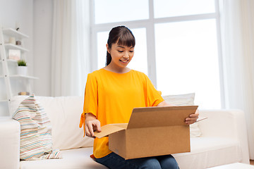 Image showing happy asian young woman with parcel box at home