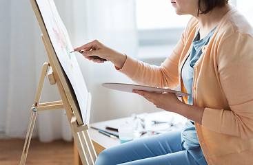 Image showing artist with palette knife painting at art studio