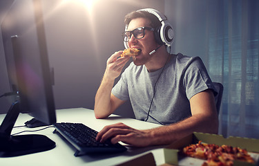 Image showing man in headset playing computer video game at home