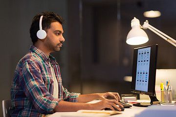 Image showing creative man in headphones with computer at office