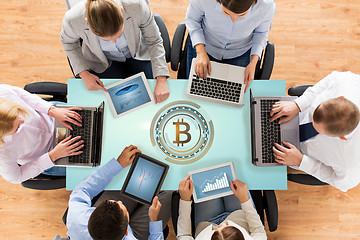 Image showing business team with computers and bitcoin hologram