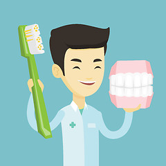 Image showing Dentist with dental jaw model and toothbrush.