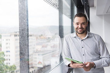 Image showing Businessman Using Tablet In Office Building by window