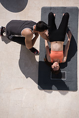 Image showing woman with personal trainer doing morning yoga exercises top vie