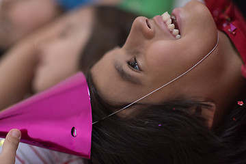 Image showing kids  blowing confetti while lying on the floor