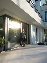 Image showing woman drinking coffee in front of her luxury home villa