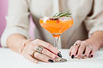 Image showing The rose exotic cocktails and fruits and female hand