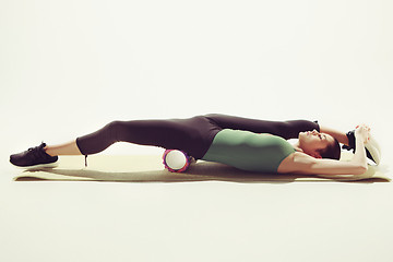 Image showing Beautiful slim brunette doing some stretching exercises in a gym