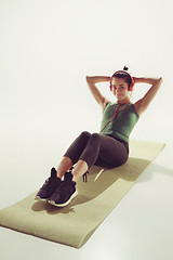 Image showing Front view of a young woman stretching body in gymnastics class.