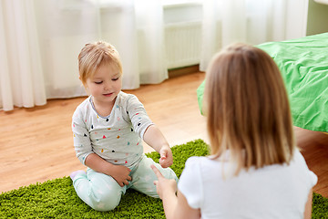 Image showing girls playing rock-paper-scissors game at home