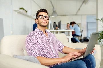 Image showing man in eyeglasses with laptop working at office