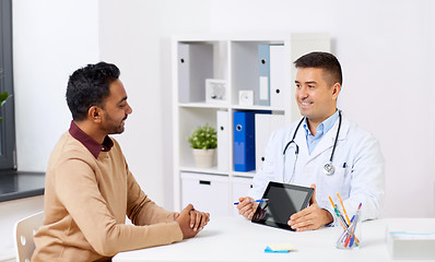Image showing happy doctor with tablet pc and patient at clinic