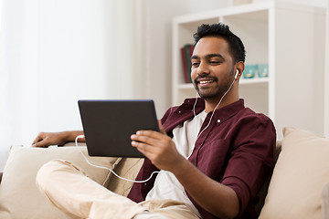 Image showing man in earphones with tablet pc listening to music