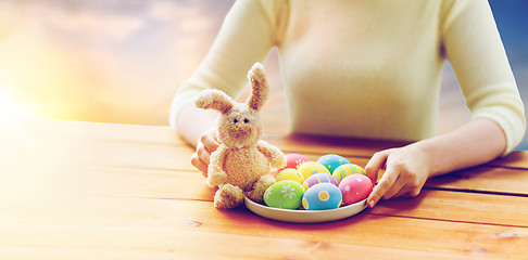 Image showing close up of woman hands with easter eggs and bunny