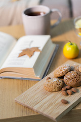 Image showing oat cookies, almonds and book on table at home