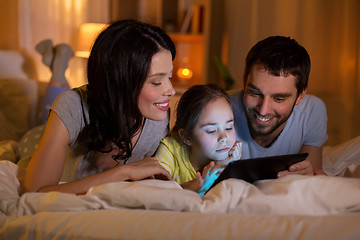 Image showing family with tablet pc in bed at night at home
