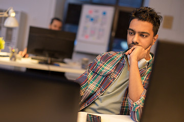 Image showing creative man with computer working at night office