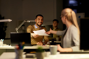 Image showing coworkers with papers working late at office