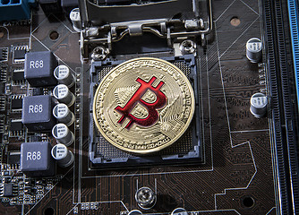 Image showing Gold Bit Coin BTC coins on the motherboard. Bitcoin is a worldwi