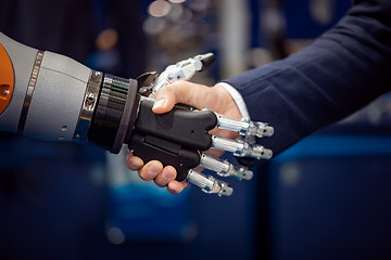 Image showing Hand of a businessman shaking hands with a Android robot.