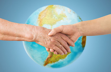 Image showing close up of senior and young woman holding hands