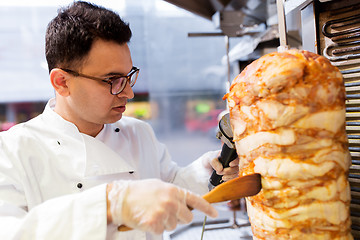 Image showing chef slicing doner meat from spit at kebab shop