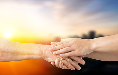 Image showing close up of senior and young woman holding hands