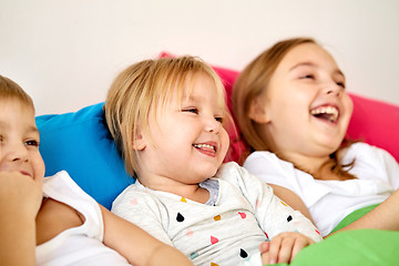 Image showing happy little kids having fun in bed at home