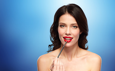 Image showing beautiful woman with make up brush for lipstick