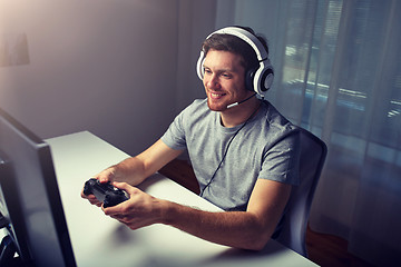 Image showing man in headset playing computer video game at home