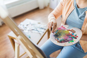 Image showing artist with palette knife painting at art studio