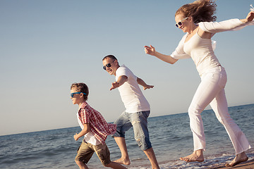 Image showing Happy family running on the beach at the day time.