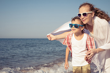 Image showing Mother and son standing on the beach at the day time.