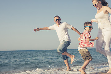 Image showing Happy family running on the beach at the day time. 