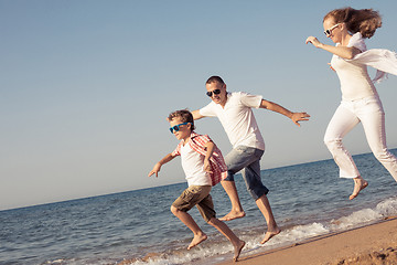 Image showing Happy family running on the beach at the day time.