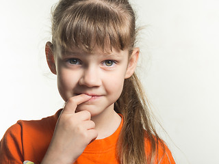 Image showing Portrait of a shy girl with finger in mouth on white background