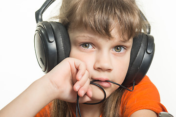 Image showing Portrait of a girl in headphones, pensive look in frame