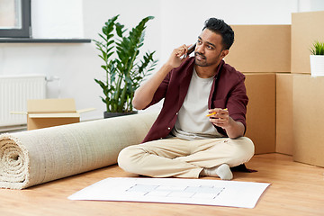 Image showing man with blueprint and boxes moving to new home