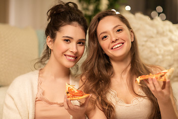 Image showing happy female friends eating pizza at home