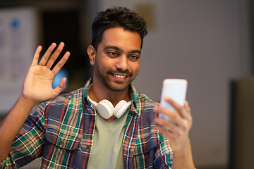 Image showing man with smartphone having video call at office