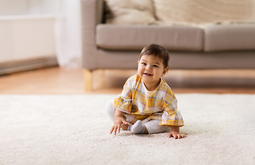 Image showing happy smiling baby girl sitting on floor home